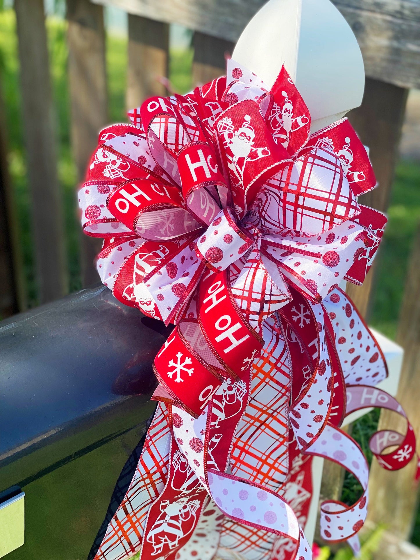 Christmas Bow in Red and White Featuring Santa Claus' and HoHoHo’s. Perfect for Mailbox, Door, and Wreath.